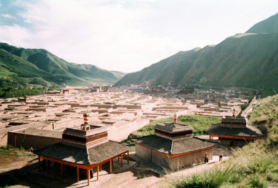 A birds-eye-view of the Labrang Monastery in Xiahe. The countless number of the maze-like buildings expands into the distance, with grass-covered mountains canvassing either side of the small city.